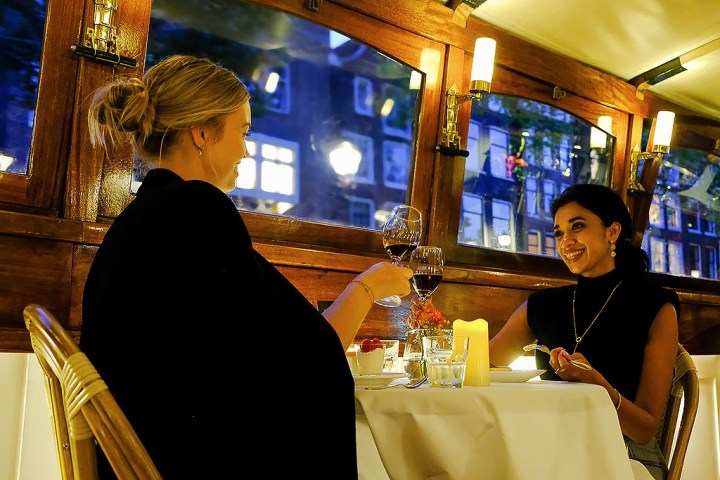 a man and a woman sitting at a table in front of a window