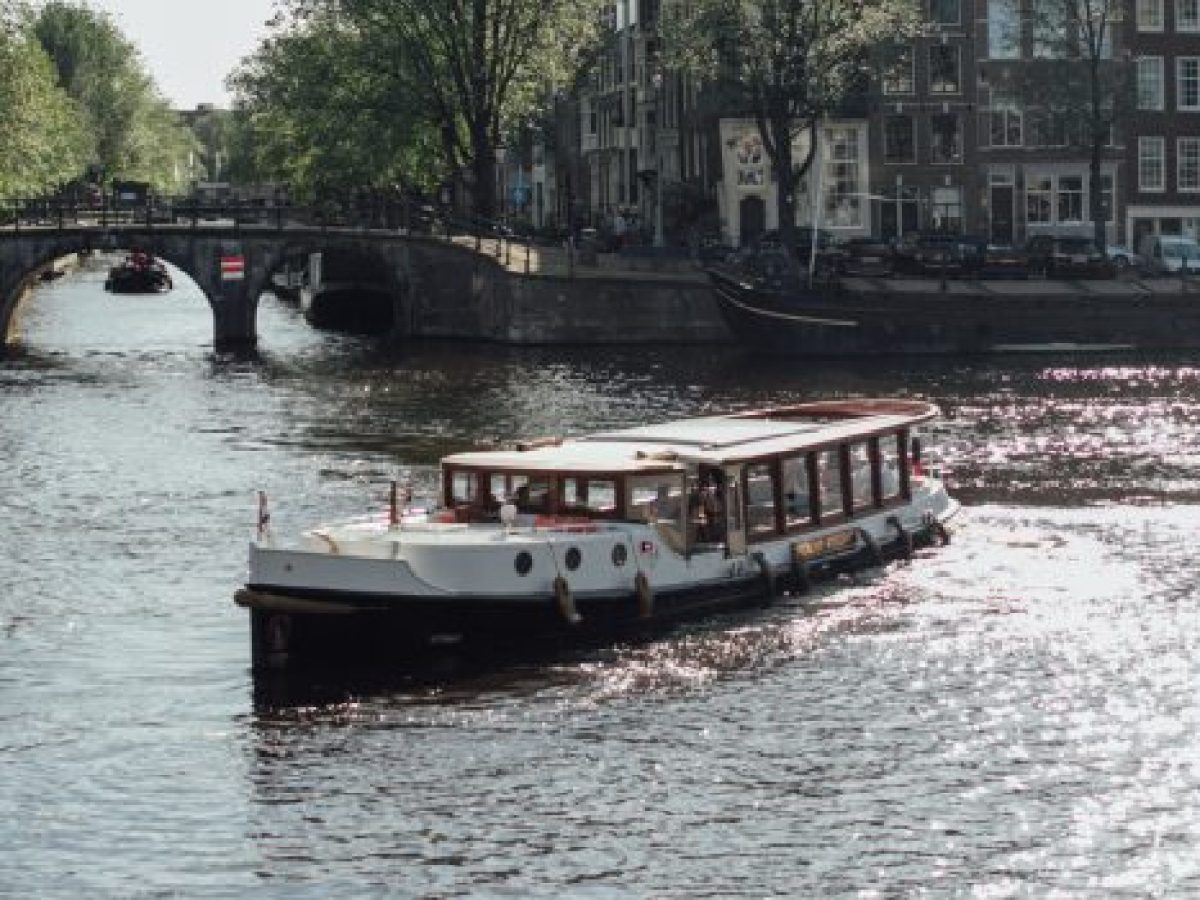 a boat traveling along a river next to a body of water