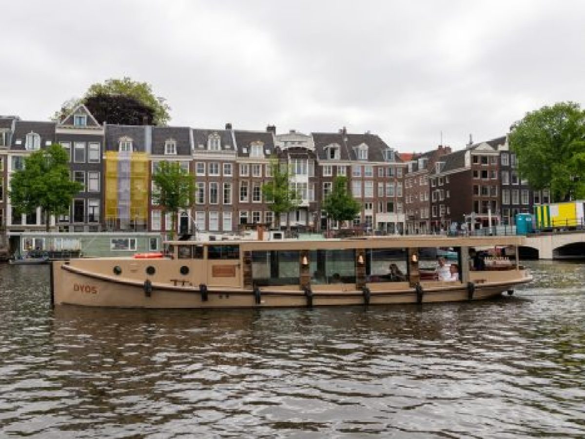 a small boat in a body of water with a city in the background