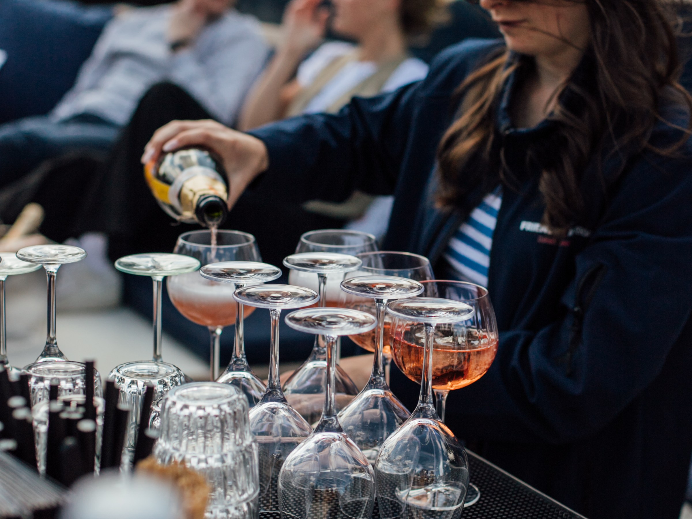 a woman sitting at a table with wine glasses