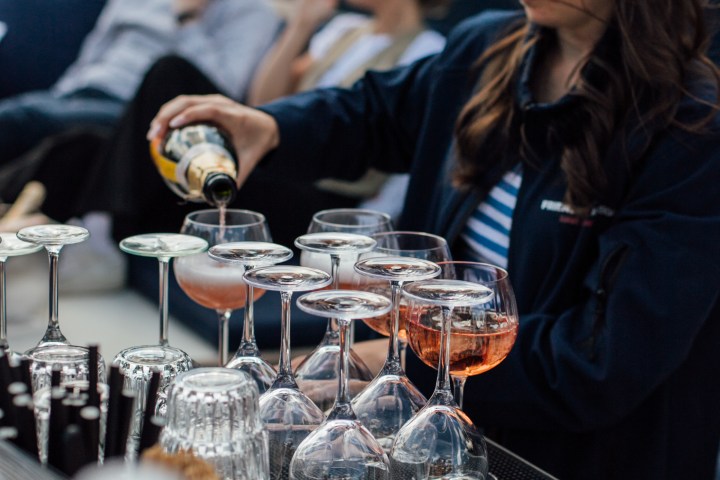 a woman sitting at a table with wine glasses