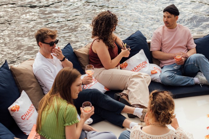 a group of people sitting next to a body of water