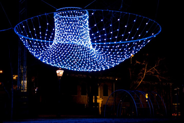 Blue LED net installation forming a funnel shape, suspended at night.