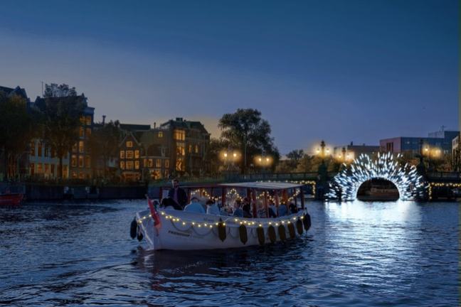 Lit boat on a canal at night with illuminated arch in the background.